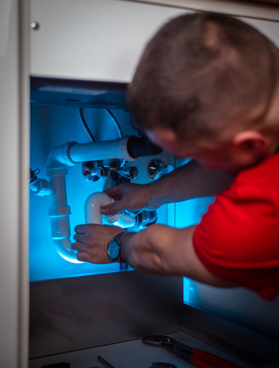 Plumber replacing a P-trap under a kitchen sink